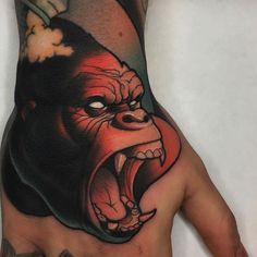 a man's hand with an angry gorilla tattoo on the left side of his arm