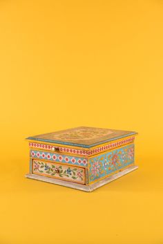 an ornately decorated box on a yellow background