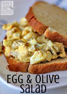 an egg and olive salad on a white plate with bread in the background text reads egg & olive salad