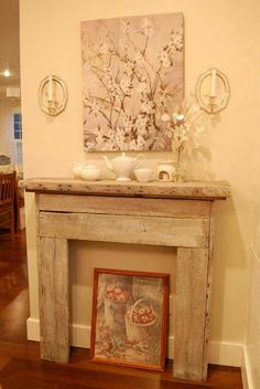 an old fireplace mantel with a painting on the mantle and vases above it