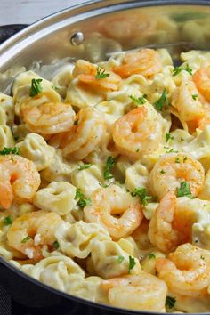 a pan filled with pasta and shrimp on top of a table