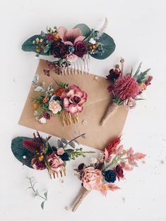 some flowers are laying on top of a piece of brown paper and two combs