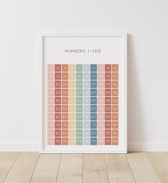 a white framed poster with numbers and times on it in front of a wooden floor