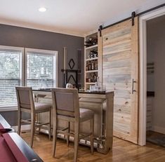 a pool table and some chairs in a room with wood flooring on the walls