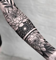 a black and white flower tattoo on the arm