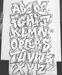 an old fashioned graffiti alphabet is displayed on a piece of white paper with black ink