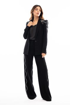 This jet black jacket is cut from Italian crepe and is rendered with 3D flowers on the shoulders. Paired with a matching embellished slip and wide legged pants. Chic Embellished Pants For Fall, Luxury Evening Pantsuit For Fall, Elegant Embellished Formal Pantsuit, Embellished Evening Pants For Fall, Chic Evening Pantsuit With Sequins, Spring Party Tuxedo Pantsuit, Black Embellished Formal Pants, Formal Embellished Black Pants, Elegant Embellished Pants For Spring