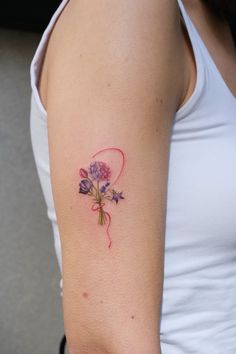 a woman with a flower tattoo on her left arm and right arm behind her back