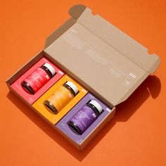 an open box with four different types of hair care products in it on an orange background