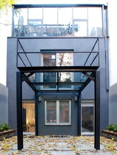 an outdoor covered patio in front of a building with lots of leaves on the ground