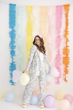 a woman standing in front of balloons and streamers with her hands on her hips