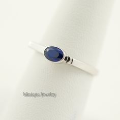 September Birthstone Ring, Oval Shaped Sapphire Blue Gem, Sterling Silver Sapphire Ring, Geometric shape Ring, Dainty Minimalist Blue Ring. An elegant and minimalist design with a Sapphire Blue Colored CZ ring. The gem is oval-shaped. Dimensions: The bandwidth: 2 mm Gemstone: 6 mm X 4 mm Around 2. 20 grams. Material: Sterling Silver (0.925) Finish: High polish with Rhodium plating. Minimalist Blue Sapphire Promise Ring, Modern Oval Stackable Rings As Gift, Modern Oval Stackable Rings Gift, Minimalist Oval Stackable Birthstone Ring, Minimalist Oval Sapphire Ring, Formal Blue Sterling Silver Stackable Rings, Elegant Blue Stackable Midi Rings, Modern Blue Stackable Jewelry, Blue Oval Stackable Rings For Anniversary