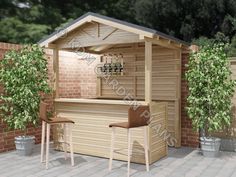 an outdoor bar with two stools next to it and a brick wall in the background