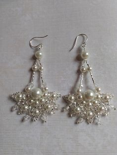 Pretty lacy medallion chandelier earrings.  These earrings are based on a design by Agnieszka Watts.  This pair are like elaborate wedding appliqués.  White pearls and crystal clear bicones surrounded with silver lined crystal seed beads. A one of a kind pair of earrings for a special occasion. Handmade White Dangle Cluster Earrings, Handmade Elegant Chandelier Earrings With Round Beads, Elegant Handmade Chandelier Earrings With Round Beads, Elegant Handmade Beaded Chandelier Earrings, White Round Chandelier Earrings Pierced, Handmade Silver Cluster Earrings For Wedding, Handmade Dangle Pearl Earrings For Celebrations, Handmade Elegant Round Chandelier Earrings, Handmade Round Chandelier Earrings For Celebration