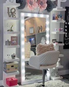 a white chair sitting in front of a mirror on top of a desk next to a wall