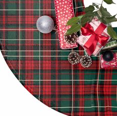 a plaid table cloth with christmas decorations and presents on it next to a silver ornament