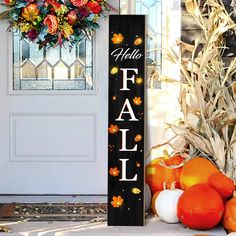 a wooden sign that says fall next to pumpkins and cornstatches in front of a door