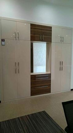 an empty room with white cabinets and drawers