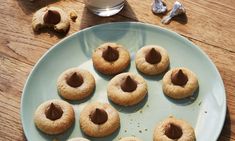 chocolate chip cookies are arranged on a blue plate next to a glass of milk and silverware