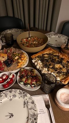 a table topped with plates and bowls filled with different types of food on top of it