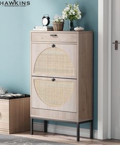 a wooden cabinet with two drawers and a basket on top of it next to a blue wall