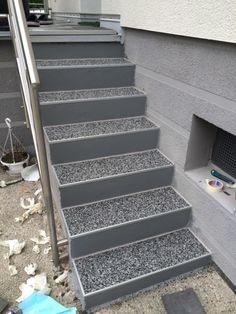 a set of stairs leading up to the top of a building with gravel on it