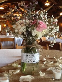 a vase filled with flowers sitting on top of a table next to glasses and napkins