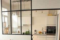 a living room filled with furniture next to a kitchen and dining room table in front of a window