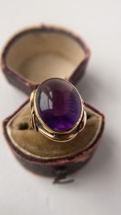 A most attractive amethyst cabochon ring set in 18ct yellow gold. Featuring a large oval amethyst cabochon of a stunning vivid purple that just glows from within. It measures 26 x 22mm and is simply but beautifully set in solid gold, with swirl detailed shoulders that are a wonderful nod to the French Decorative Arts and Crafts era. In good antique condition, there is some slight wear commensurate with age, this is an Impressive and beautiful ring that draws the eye and makes a statement. Solid Arts And Crafts Era, Oval Amethyst Ring, Amethyst Ring Vintage, Cabochon Ring, Beautiful Ring, Ring Vintage, Amethyst Ring, Rings Statement, Ring Set