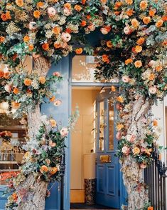 an entrance to a store decorated with flowers