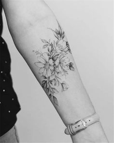 a woman's arm with flowers on it and lines in the background that show where she is going to get her tattoo