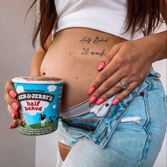 a pregnant woman holding a cup of ice cream with writing on her stomach that reads, happy birth 20 week