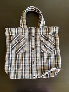 a brown and white plaid bag sitting on top of a table