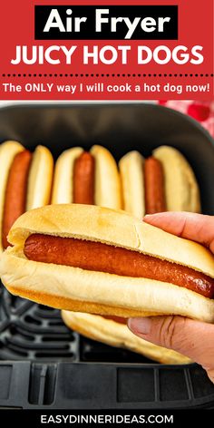 a person holding a hot dog in their hand with the words air fryer juicy hot dogs