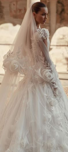 a woman in a wedding dress with flowers on the back and veil over her head