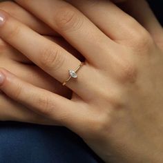 a woman's hand with a diamond ring on it