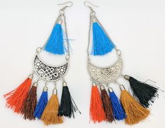 Brown, Blues, Orange colors make for a fascinating earrings.  These fashion drop dangle tassel earrings are silver-tone earrings with intricate carving on the circular metal and multicolor thread bells on the bottom forming the body of the earrings. #tlb #bohogift #Indian #Handmade #tasselearring #gypsytasselearrings Silver Metal Chandelier Earrings With Tassels, Metal Tassel Earrings For Festival, Tassel Metal Earrings For Festival, Silver Bohemian Tassel Earrings With Fringe, Bohemian Silver Fringe Earrings, Silver Fringe Bohemian Earrings, Bohemian Silver Tassel Earrings, Silver Bohemian Fringe Earrings, Traditional Multicolor Fringe Earrings