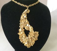 "Beautiful pendant. Stylish and provocative. Sparkling gold plated dimensional faux gold nugget and chain pendant with a great looking twist link chain. Little to no wear. Beautiful gold plated statement with a flower design embedded on the lower right of the pendant. Shows best on view #3 and #4. The nugget may be an attempt at replicating a very similar looking real gold nugget found in Australia. Unsigned spectacular piece. Modernist or Brutalist appeal. 1970s 0r 80s Necklace 23 1/2\" long Pe The Nugget, Yoga Necklace, Clover Pendant, Birth Mother, Cz Bracelet, Mother Jewelry, Enamel Beads, Gold Nugget, Silver Circle