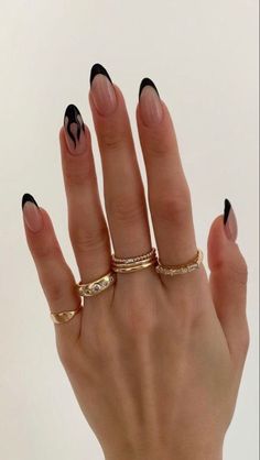 a woman's hand with black and white manicures on it, holding her ring