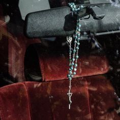 a rosary hanging from the back of a car