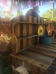 an outdoor area with wooden shelves and potted plants