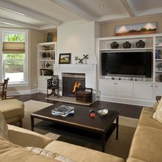 a living room filled with furniture and a flat screen tv mounted on a wall above a fire place