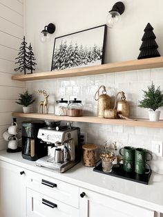 a kitchen with white cabinets and shelves filled with christmas decorations