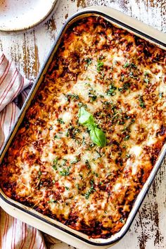 a casserole dish with cheese and herbs on top, ready to be eaten