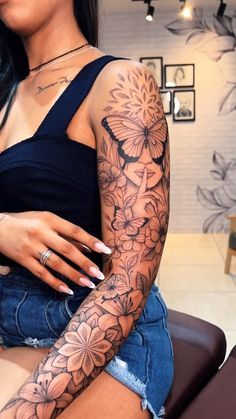 a woman sitting on top of a chair with tattoos on her arm