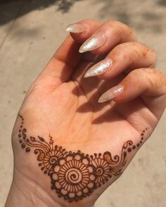 someone is holding their hand with henna on it