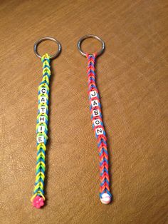 two key chains with letters on them sitting on a table