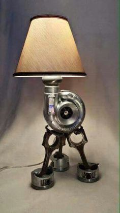 a lamp that is sitting on top of a metal object with gears attached to it