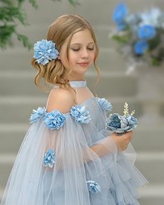 This Alaska Baby Blue Tulle Dress is a dream come true for every little girl! With its amad satin tulle fabric, cape sleeves, below the knee poofy skirt, and hand beaded snowflakes and flowers, it's a showstopper. The ice blue color will make your little one feel like a winter princess! Sky blue color Below the knee Back button and zipper closure Silver beading embroidery on bodice Cape sleeves with flowers Amad Satin and tulle 70% Polyester, 30% Silk , 100% Cotton lining, beautiful flowers on c Baby Blue Tulle Dress, Poofy Skirt, Blue Tulle Dress, Ice Blue Color, Beading Embroidery, Winter Princess, Hair Clasp, Kenzie Ziegler