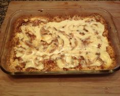 a casserole dish with cheese sauce and mushrooms in it on a wooden table